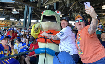 Mariners mascot Humpy the salmon is enthusiastically hugged by fans.