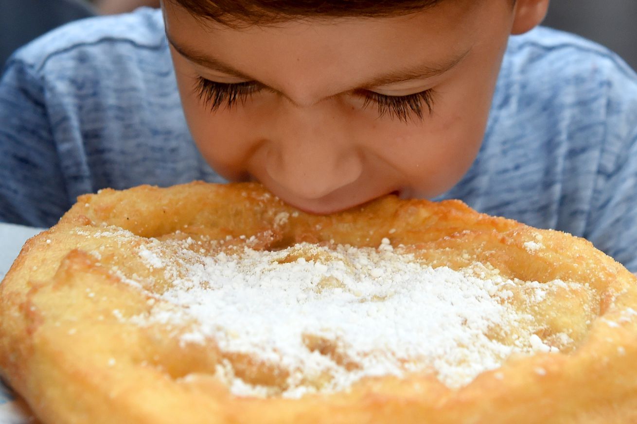 BOSTON AUGUST 12: Julius Daddario, 4, of Boston, eats a freshly cooked up piece of fried dough, during the annual Fisherman’s Feast festival in the north end, Sunday, August 18, 2019, in Boston. (Jim Michaud / MediaNews Group/Boston Herald)