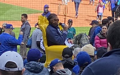 Felix Hernandez sits on a throne at T-Mobile Park while holding a microphone and speaking to the crowd.