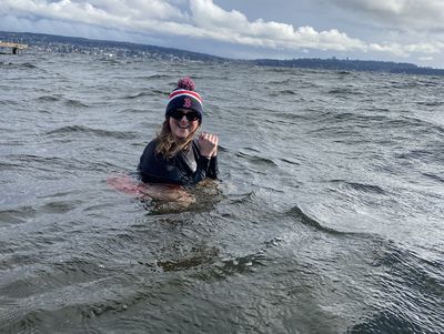 In a Red Sox hat, Maura McGurk plunges in the cold water of Lake Washington.